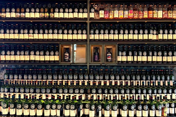Rows of bottles lined up on shelves, filled with various colored liquids.