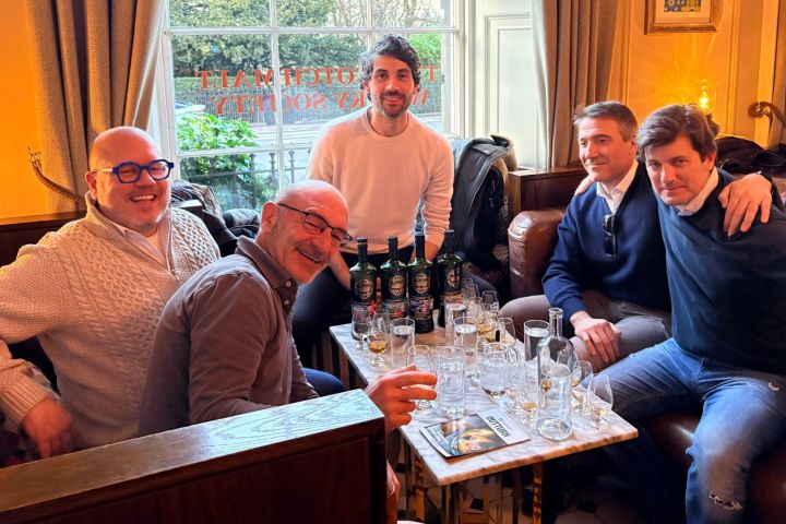 Small group celebrating a private single cask whisky tasting session with founder Camilo in a luxury club room.