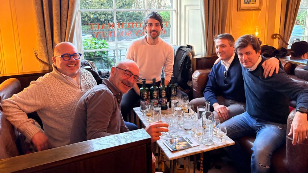 Small group celebrating a private single cask whisky tasting session with founder Camilo in a luxury club room.