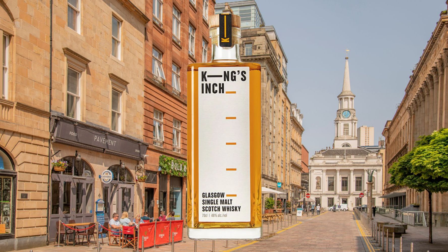 Giant whisky bottle in urban street with people dining and historic building in background.