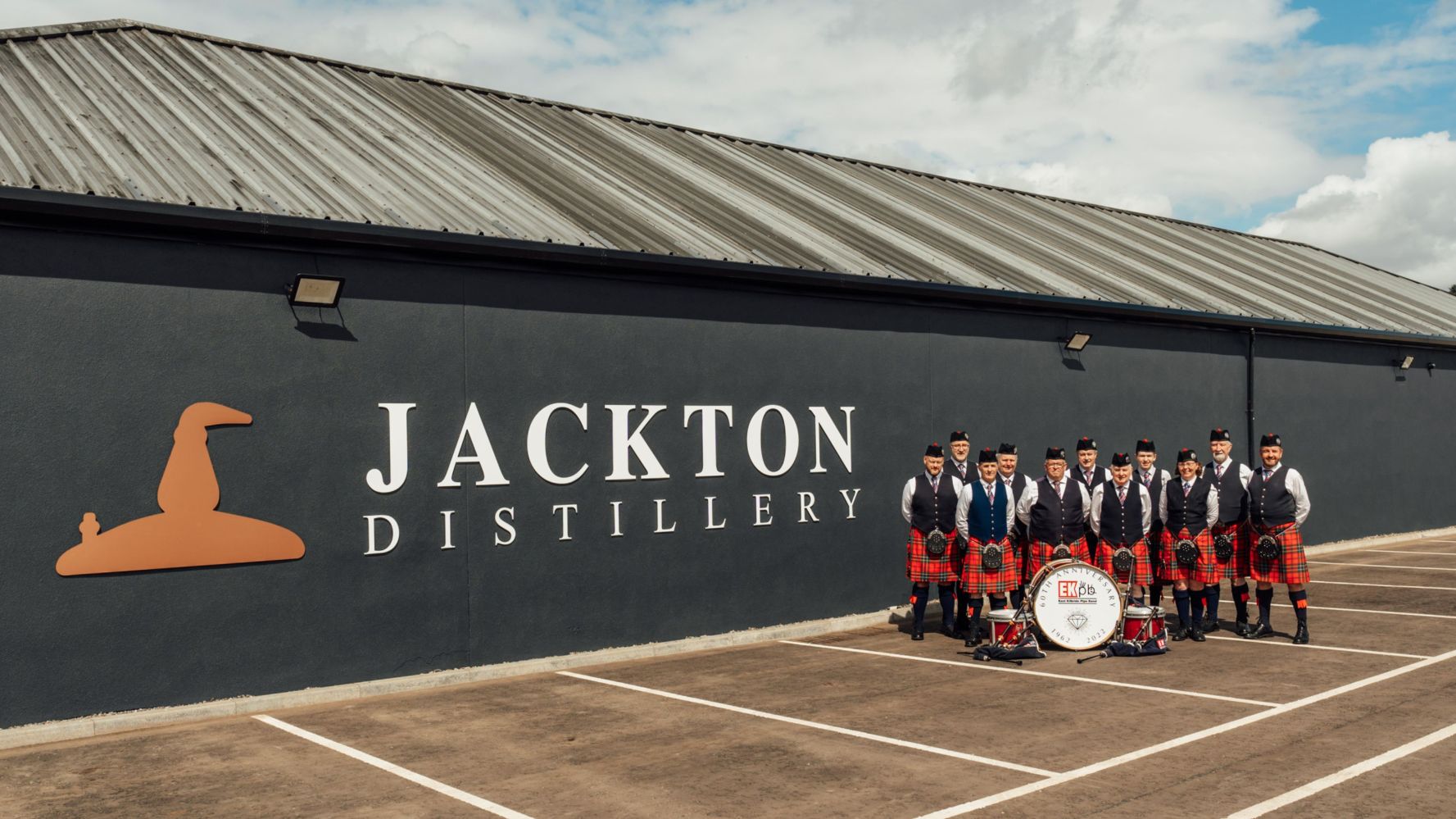 A group of bagpipers in front of Jackton Distillery