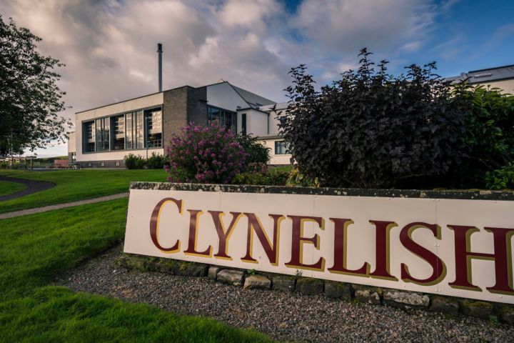 Exterior of a building with 'Clynelish' sign, green lawn, and cloudy sky.